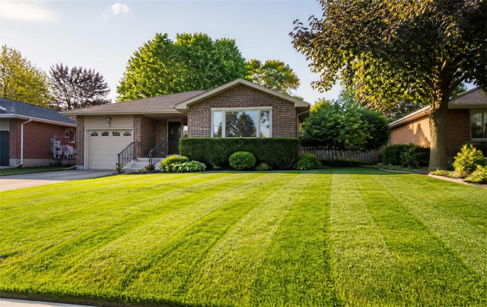 Freshly mowed striped lawn in front of a brick home